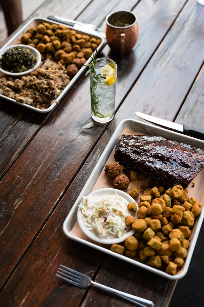 Barbecue feast on a wooden table with pulled pork, fried croquettes, coleslaw