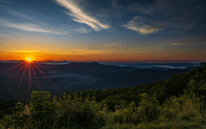 Find Your Way Back In the Mountains Blog Featured Sunrise over layered blue ridge mountain ridges with mist in the valleys and a vivid orange and blue sky near saluda, north carolina.